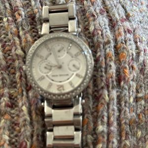 Michael Kors watch. Silver with stones around the face and on the clock face.